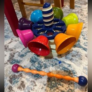 Montessori spinning bell toy with matching striker to hear different sounds.